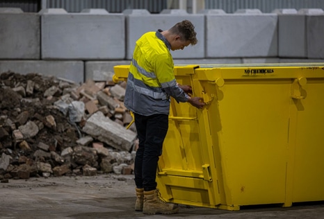 Man Inspecting Yellow Bin — Skips for Hire in Albion Park Rail, NSW
