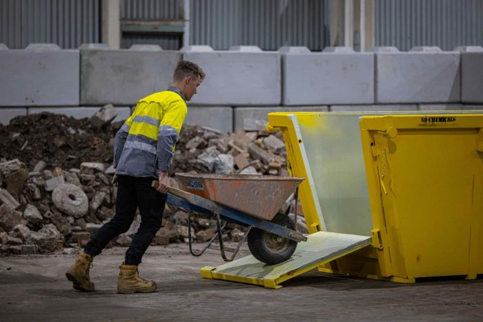 Man Pushing Skip Bin Pull Of Rock— Contact Us in Shellharbour, NSW
